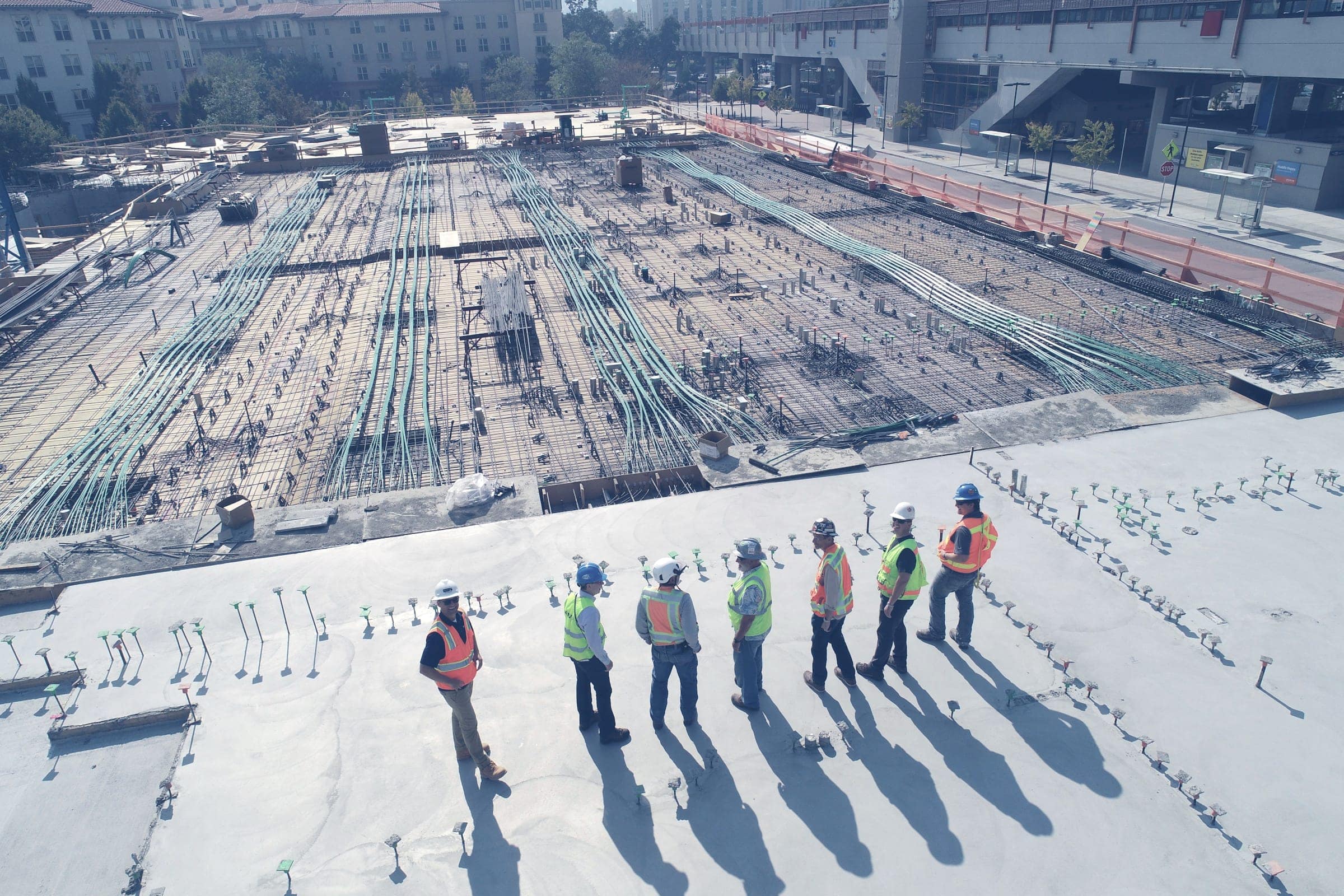 Engineers in safety gear standing on a large construction site